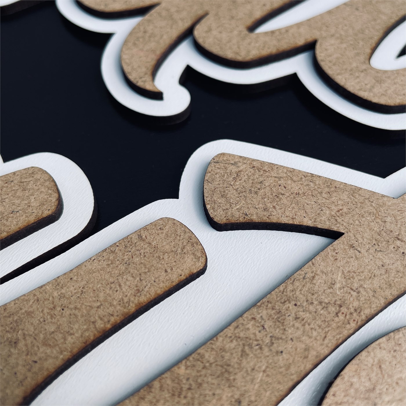 Adventure Awaits Macro Detail of Fluid Script Flourish and Laser Cut Contours